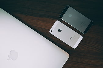 Apple MacBook and iPhones on Dark Wood Desk