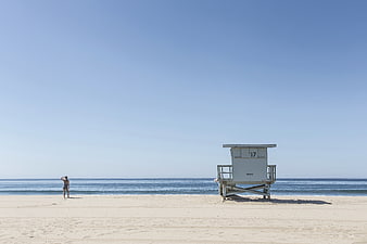 Lifeguard Tower on Sandy Beach with Woman Walking