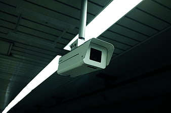 Low angle view of white CCTV security camera on ceiling