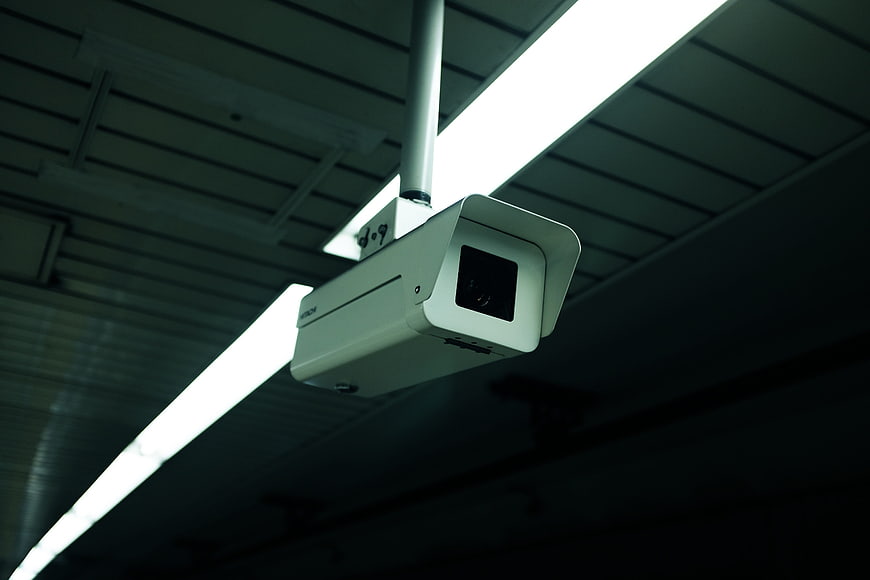 Low angle view of white CCTV security camera on ceiling
