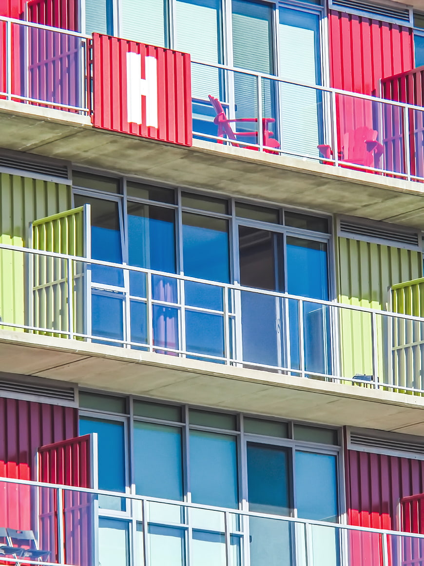 Colorful modern apartment building with red and green balconies