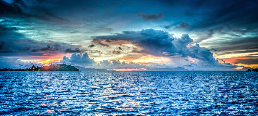 Dramatic Sunset Over Tropical Ocean with Distant Island