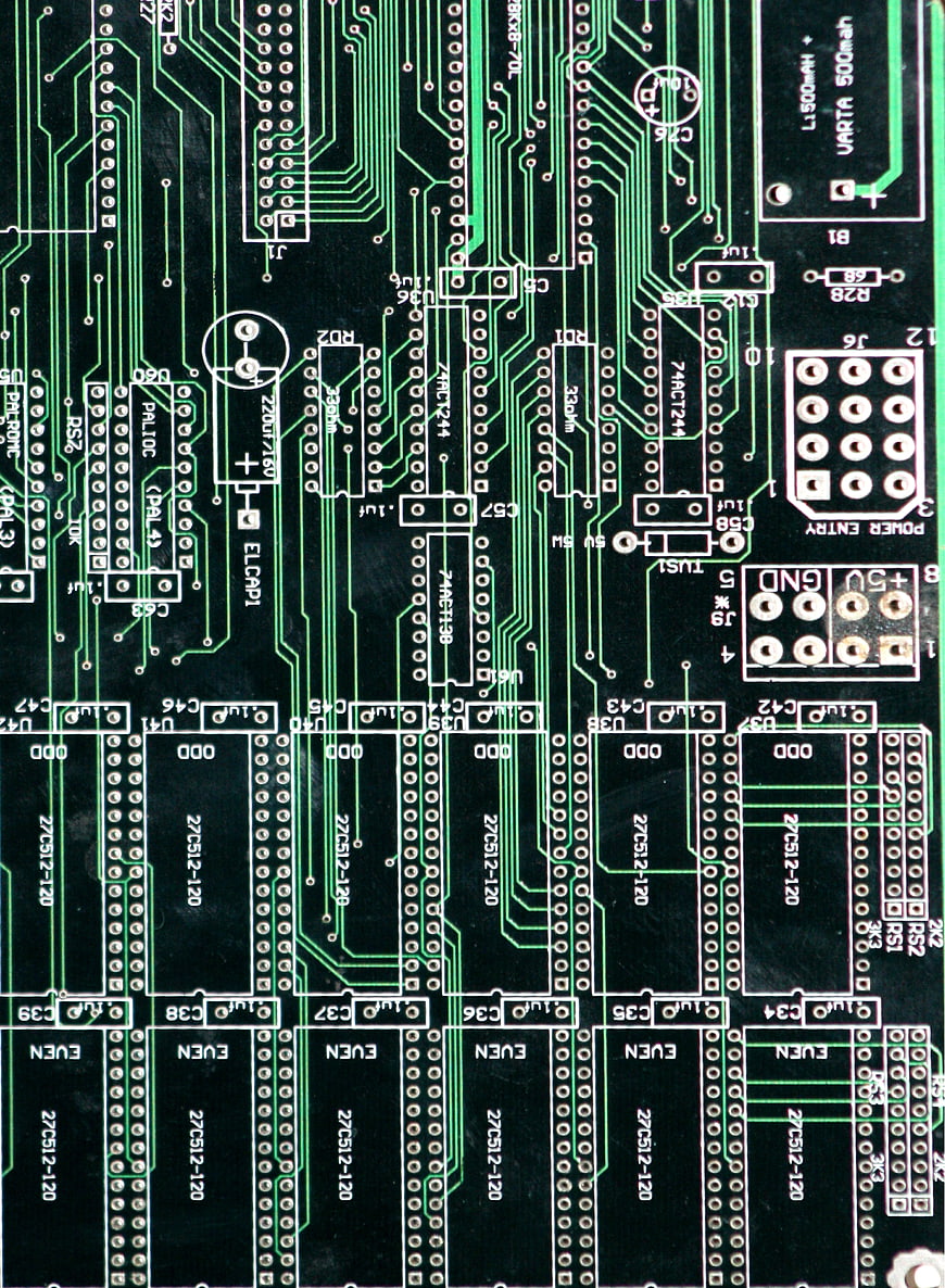 Close-up of green printed circuit board with electronic components and traces