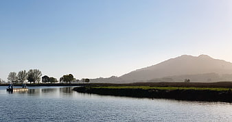 Serene River Landscape with Misty Mountain Backdrop