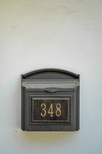 Black Wall Mailbox with House Number 348 on White Stucco