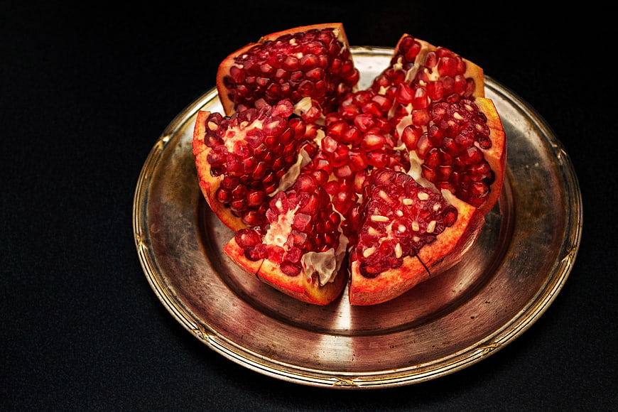 Fresh Pomegranate Segments on Vintage Brass Plate