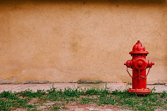 Red Fire Hydrant Against Textured Beige Wall