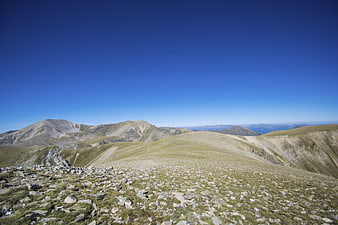 Panoramic Alpine Mountain Landscape with Rocky Foreground and Blue Sky