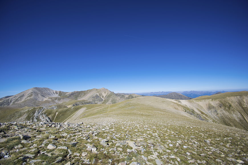 Panoramic Alpine Mountain Landscape with Rocky Foreground and Blue Sky