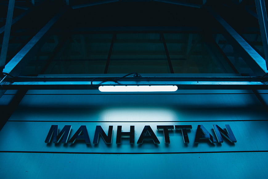 Manhattan subway station sign illuminated at night