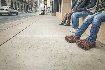 People Wearing Funny Animal Slippers on City Sidewalk
