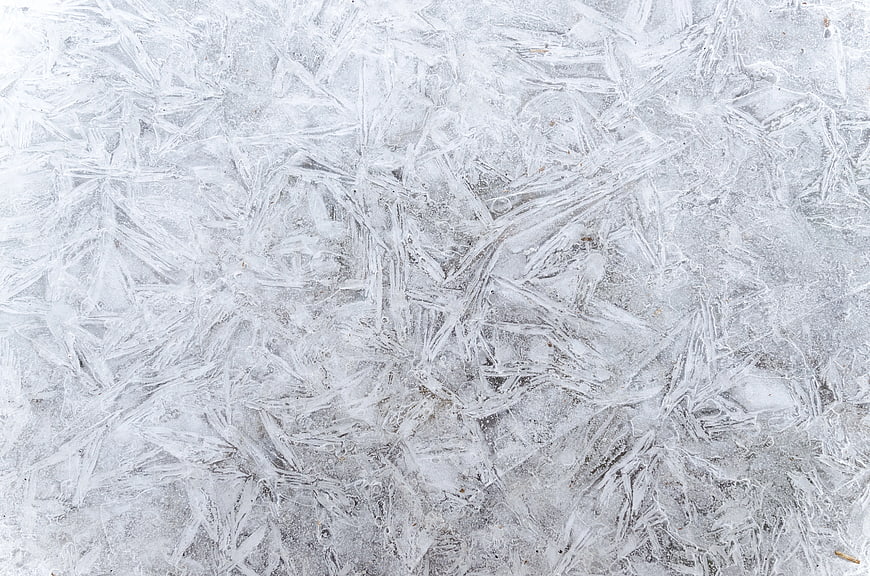 Close-up of intricate ice crystals and frost patterns on frozen surface