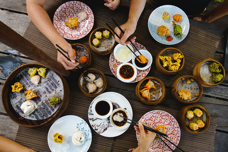 Top View of Hands Eating Chinese Dim Sum Feast