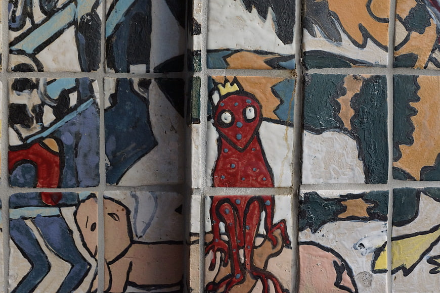 Hand-painted ceramic tiles with whimsical red frog art