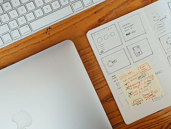UX Design Workspace with Laptop, Keyboard, and Wireframe Sketches