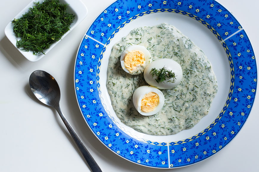 Traditional Czech dill sauce with boiled eggs on blue plate