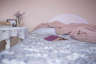 Cozy Bedroom Interior with Open Book and Pink Blanket
