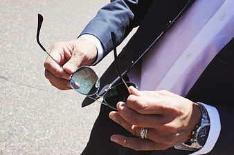 Man in Suit Holding Sunglasses and Wearing Watch