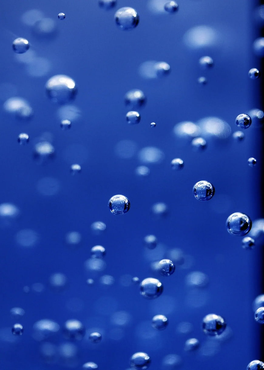 Close-up of rising air bubbles in blue water