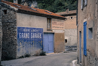 Vintage French Village Street with Faded Hotel and Garage Signs
