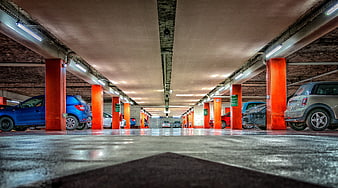Low angle view of underground parking garage with orange pillars