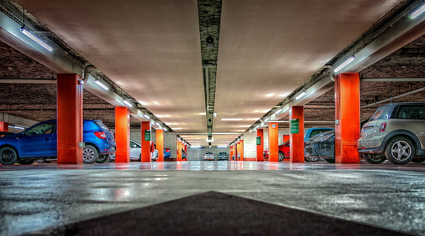 Low angle view of underground parking garage with orange pillars