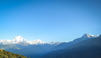 Snow-capped Himalayan mountain peaks under clear blue sky