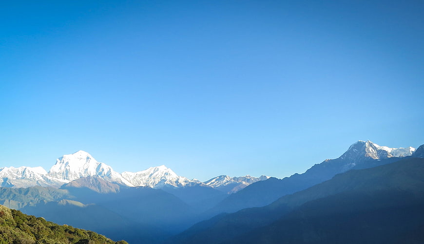 Snow-capped Himalayan mountain peaks under clear blue sky