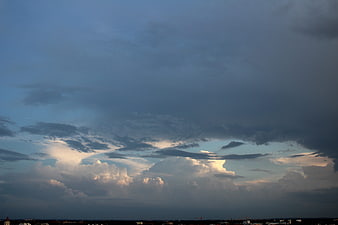 Dramatic storm clouds over city skyline at dusk