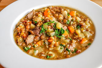 Hearty lentil and vegetable stew in a white bowl
