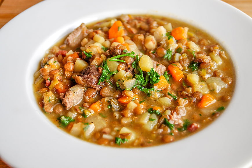 Hearty lentil and vegetable stew in a white bowl
