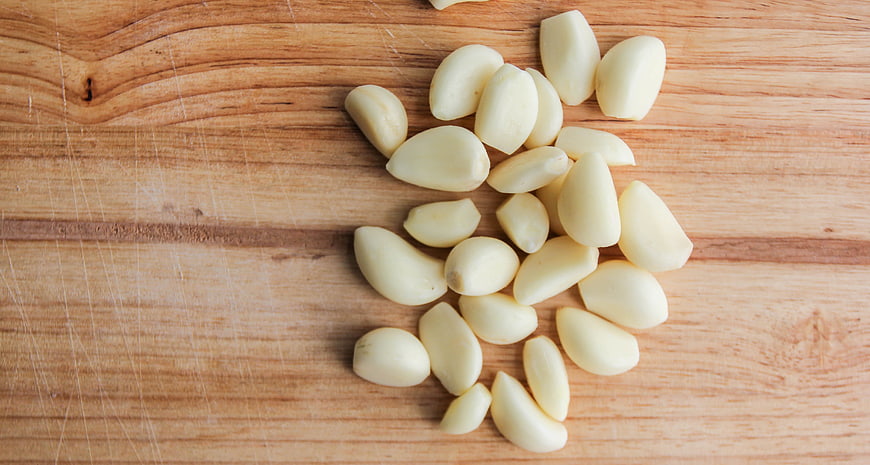 Peeled Garlic Cloves on Wooden Cutting Board