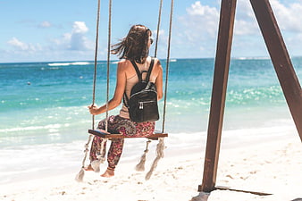 Woman on Beach Swing Facing Ocean