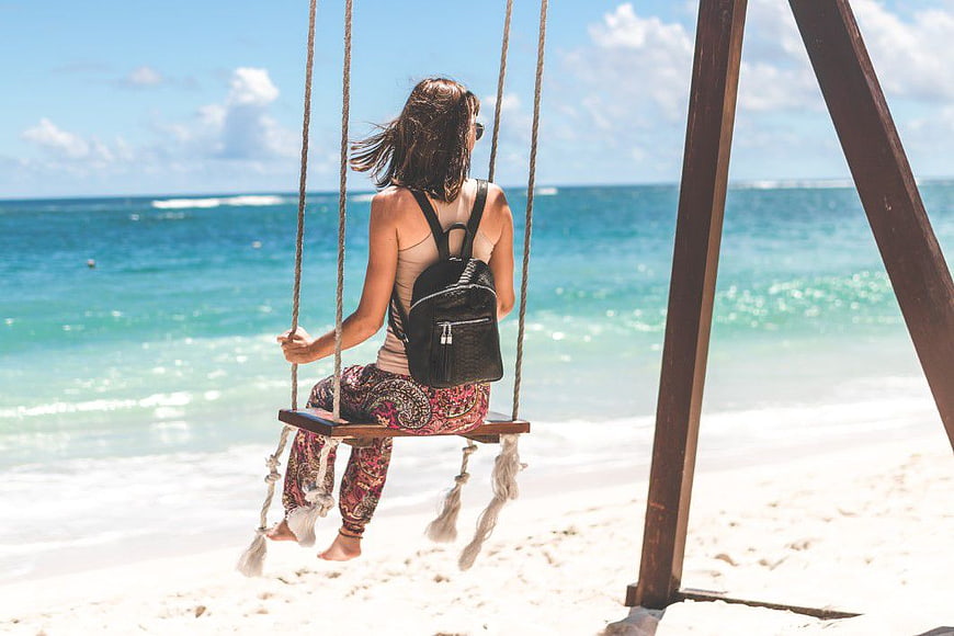 Woman on Beach Swing Facing Ocean