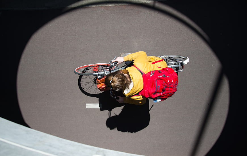 High Angle View of Cyclist with Red Backpack on Bike Path
