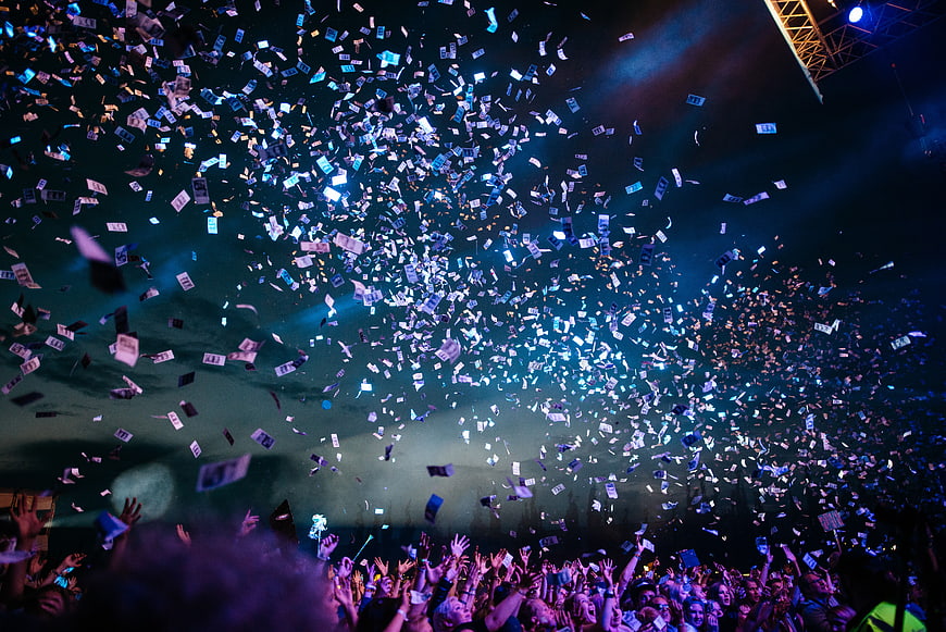 Crowd at concert with falling confetti and stage lights
