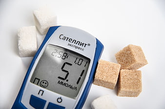 Blood Glucose Meter Displaying 5.1 mmol/L With Sugar Cubes