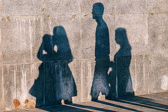 Abstract Human Silhouettes Cast On Textured Urban Concrete Wall