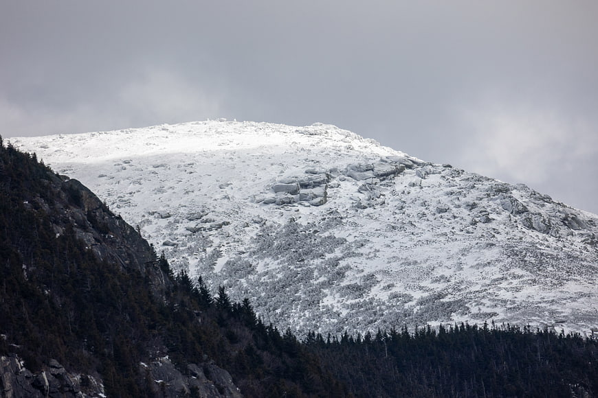 Snow-Capped Mountain Peak with Dark Forest Slopes