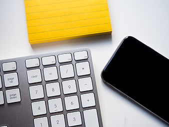 Flat Lay Office Desk with Keyboard, Smartphone, and Yellow Notepad