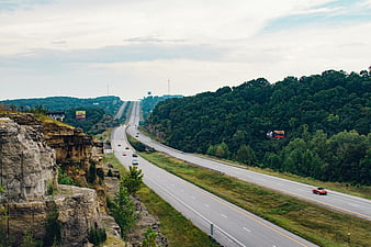 Highway Winding Through Rocky Cliffs and Forested Hills
