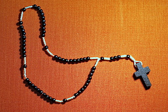 Black and White Rosary on Orange Fabric Background