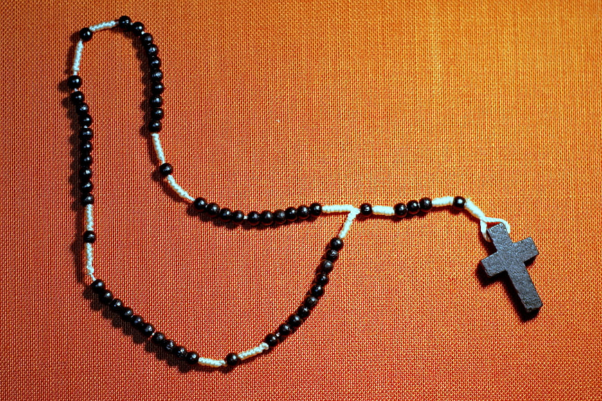 Black and White Rosary on Orange Fabric Background