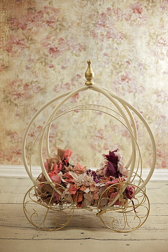 Vintage metal carriage prop with fabric petals and tiara on floral background