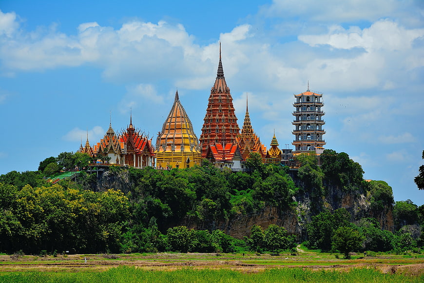 Thai Temple Complex on Hilltop with Rice Fields