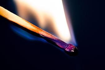 Close-up of a burning matchstick with flame and smoke