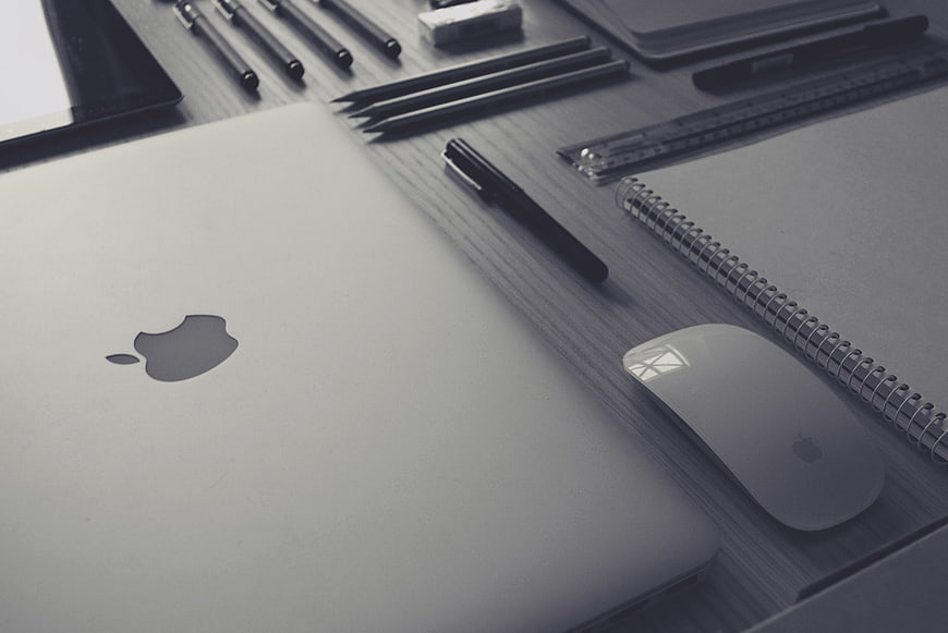 Grayscale Workspace with Laptop, Mouse, and Stationery