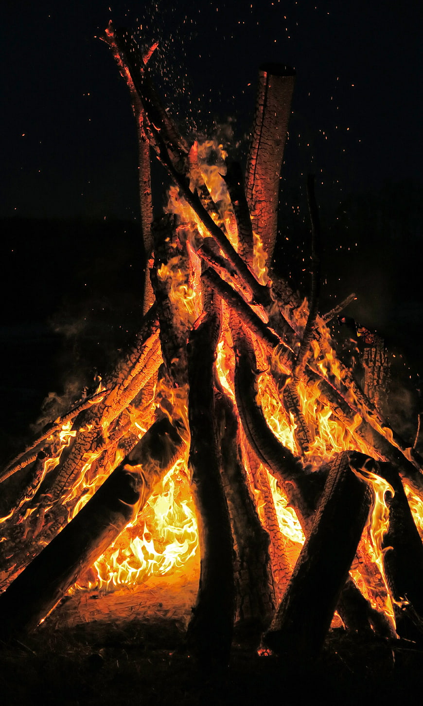 Large Bonfire Burning at Night with Sparks