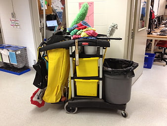 Janitorial cleaning cart with yellow bins and mop in office hallway
