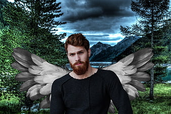 Portrait of bearded man with angel wings in mountain forest